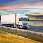 A truck drives along the highway on its way to deliver freight.