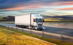 A truck drives along the highway on its way to deliver freight.