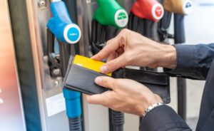 A truck driver pulls out their fuel card to pay for fuel.